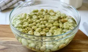 Fèves vertes dans un bol en verre, prêtes pour la cuisson.
