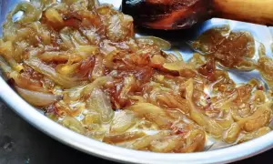 Oignons caramélisés dorés et fondants dans une poêle, prêts à sublimer un plat.