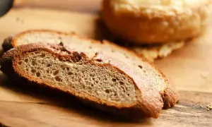 Tranches de pain artisanal sur planche en bois, parfaites pour faire de la chapelure maison.