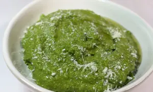 Un bol de pesto épinard frais, parsemé de copeaux de parmesan. Une touche de vert vibrant pour rehausser vos plats.