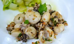 Chipiron a la plancha, tendres et savoureux, parsemés d'ail et de persil, accompagnés de légumes verts croquants.
