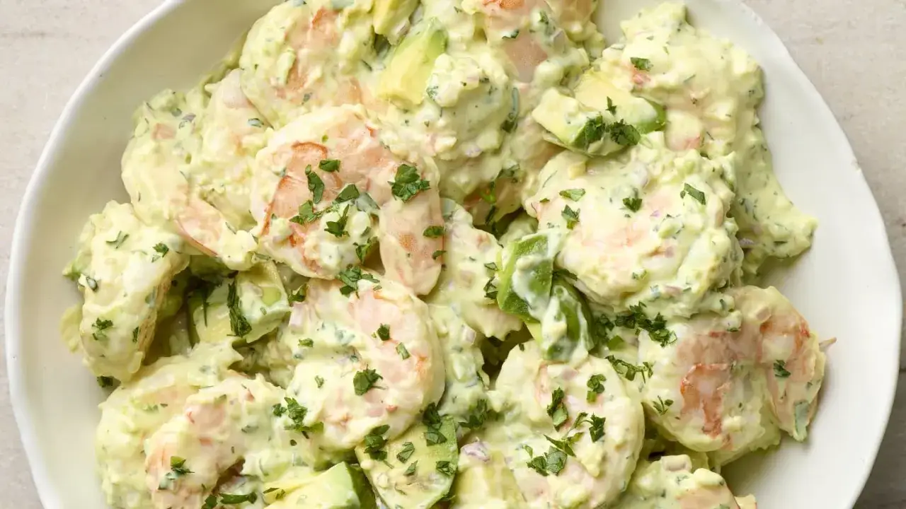 Salade avocat crevette crémeuse, garnie de persil frais. Un délice léger et savoureux.