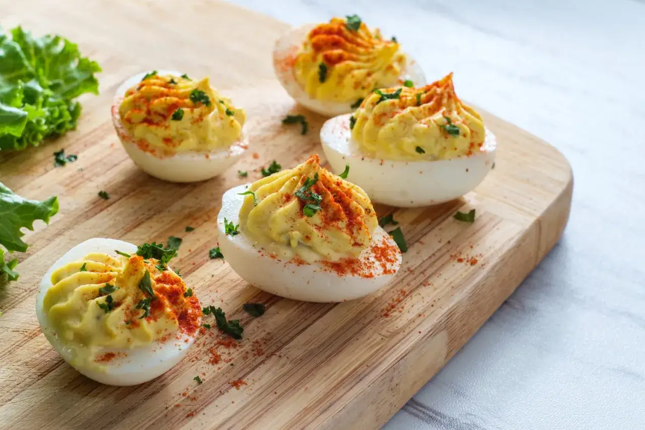 Œufs mimosa joliment décorés, prêts à être dégustés. La cuisson œuf dur est la base de cette recette savoureuse.
